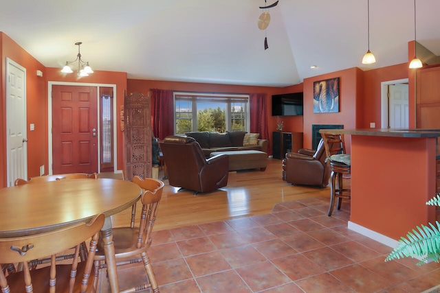 living room with a notable chandelier, lofted ceiling, and hardwood / wood-style floors