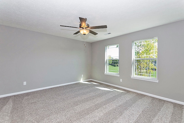 spare room featuring ceiling fan, a textured ceiling, and carpet