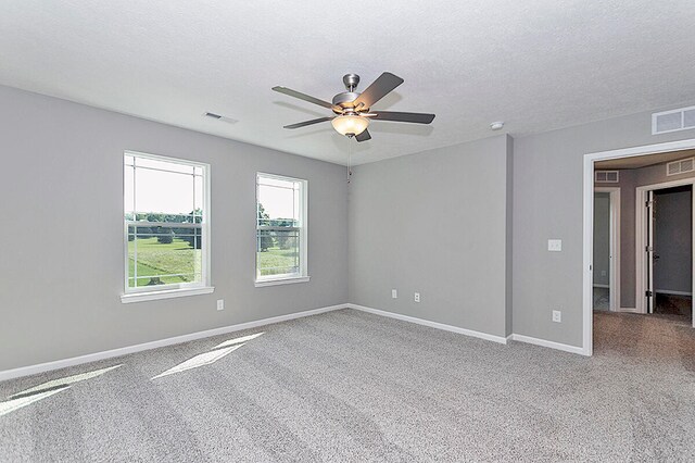 carpeted empty room with a textured ceiling and ceiling fan