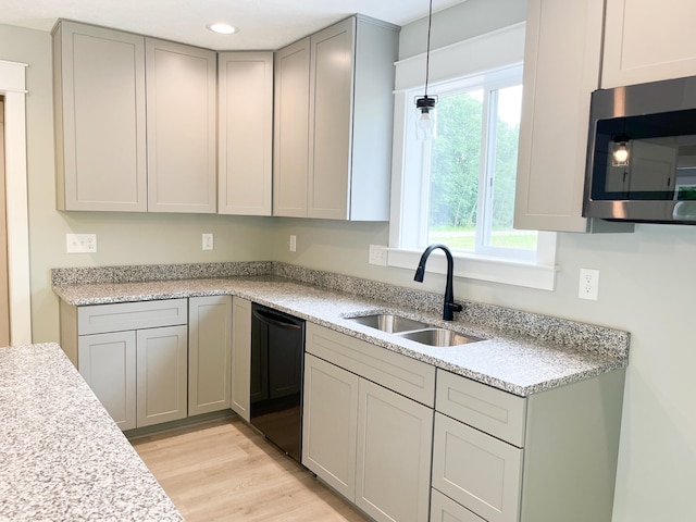 kitchen with gray cabinetry, dishwasher, pendant lighting, light hardwood / wood-style flooring, and sink