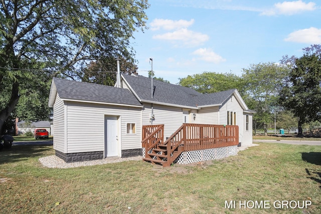 rear view of house featuring a lawn and a deck