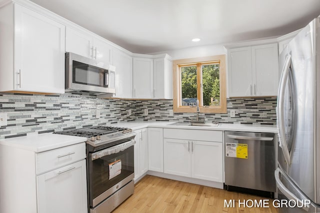 kitchen featuring white cabinetry, sink, appliances with stainless steel finishes, and tasteful backsplash