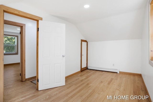 bonus room with a baseboard radiator, light hardwood / wood-style flooring, and lofted ceiling