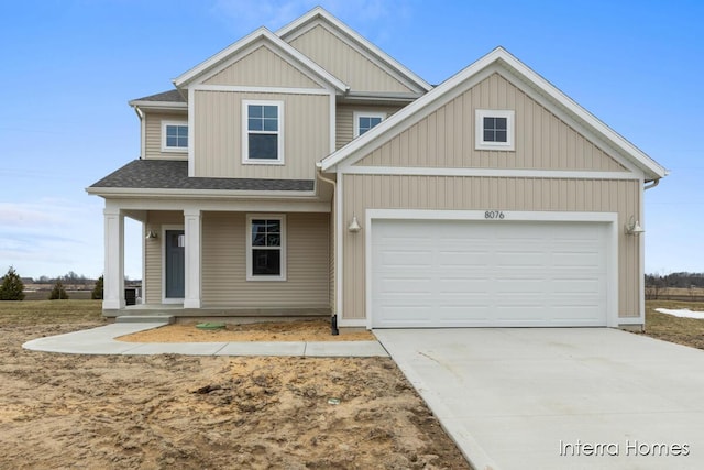 view of front of house featuring a garage, covered porch, driveway, and a shingled roof