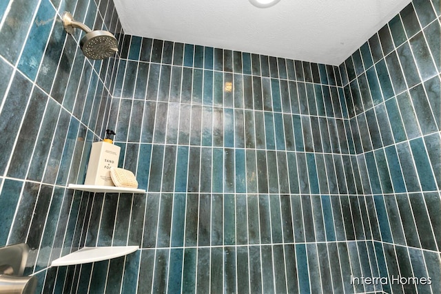 bathroom featuring a textured ceiling and tiled shower