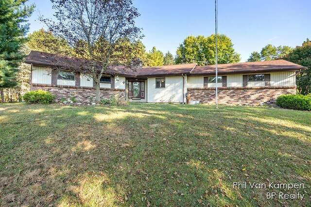 view of front of home featuring brick siding and a front yard
