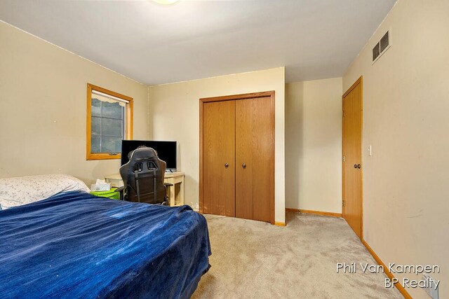 bedroom featuring carpet floors, baseboards, a closet, and visible vents
