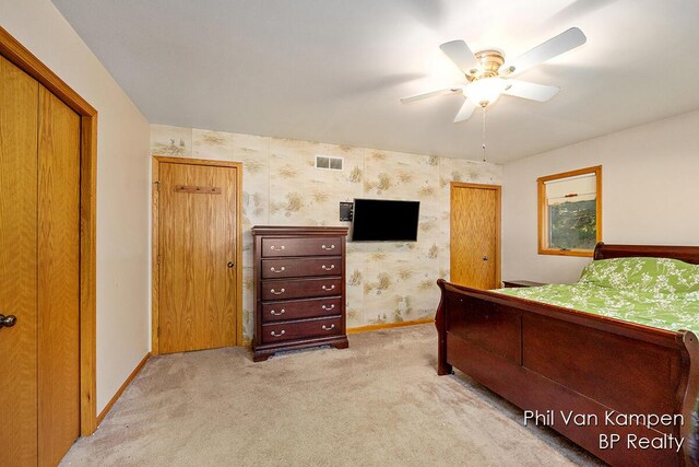 bedroom featuring light colored carpet, wallpapered walls, visible vents, and baseboards