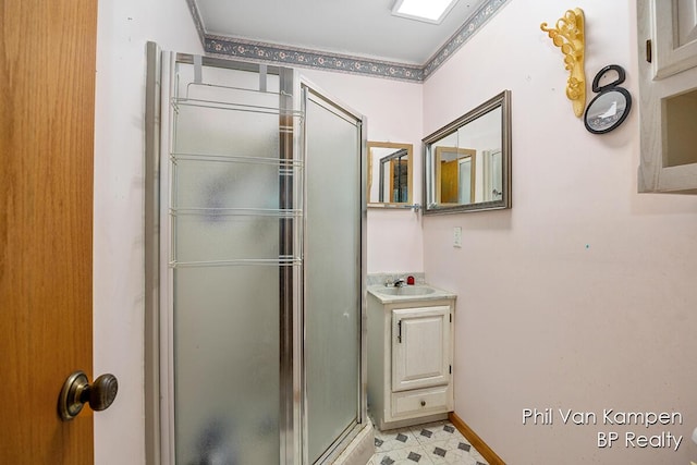 bathroom with vanity, ornamental molding, baseboards, tile patterned floors, and a stall shower