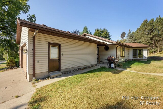 ranch-style home with driveway, a garage, and a front lawn