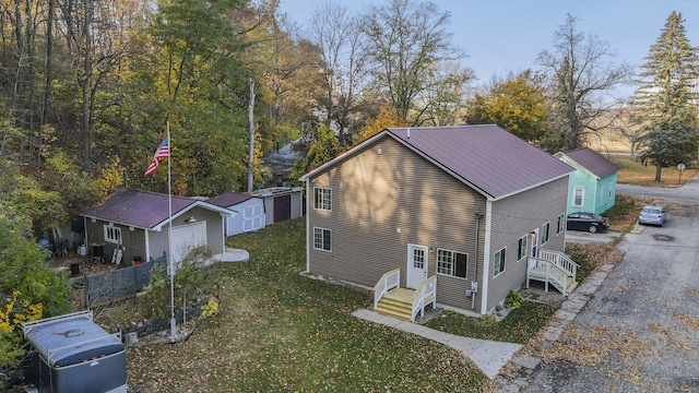 view of property exterior with a storage unit, a garage, and a lawn