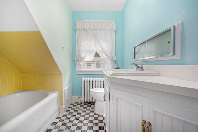 bathroom featuring radiator, vanity, toilet, and a tub