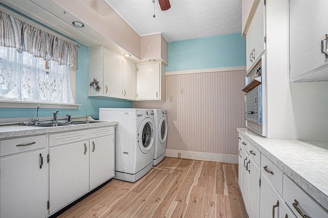 washroom with independent washer and dryer, light wood-type flooring, ceiling fan, cabinets, and sink