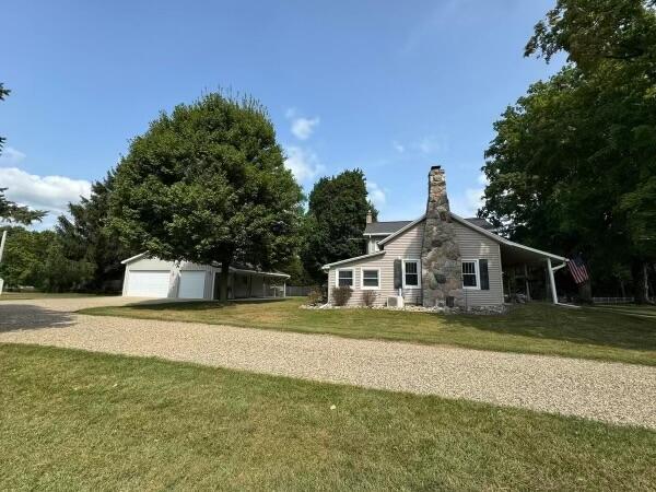 view of side of property featuring a garage and a lawn