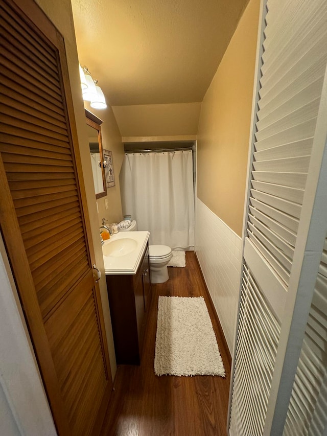 bathroom featuring vanity, toilet, walk in shower, and hardwood / wood-style floors