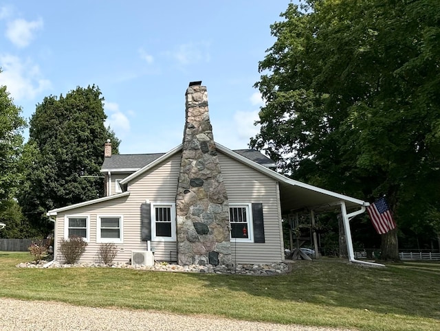 back of property featuring a lawn and a carport