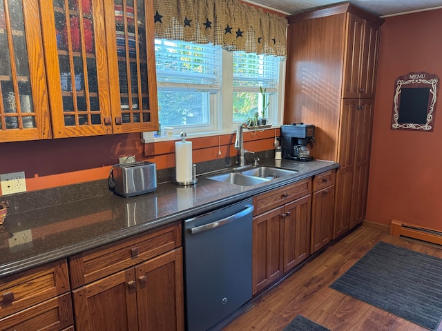 kitchen with dishwasher, dark hardwood / wood-style floors, dark stone countertops, sink, and a baseboard radiator