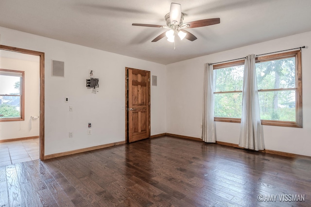 unfurnished room with ceiling fan, dark hardwood / wood-style floors, and plenty of natural light