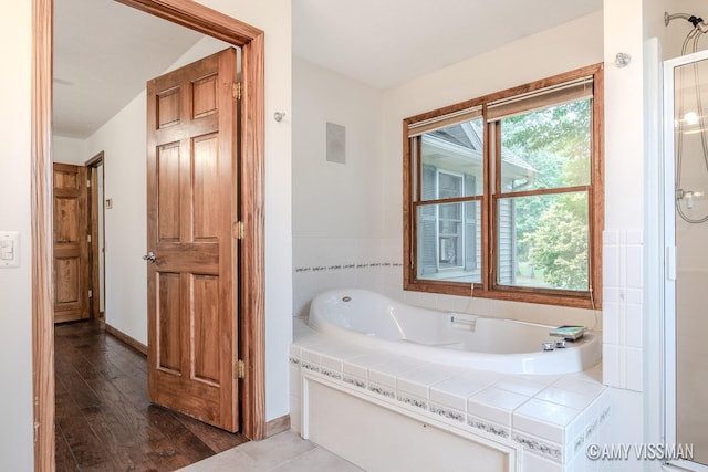 bathroom with a bath and hardwood / wood-style flooring