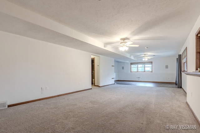 unfurnished living room featuring ceiling fan, a textured ceiling, and light carpet