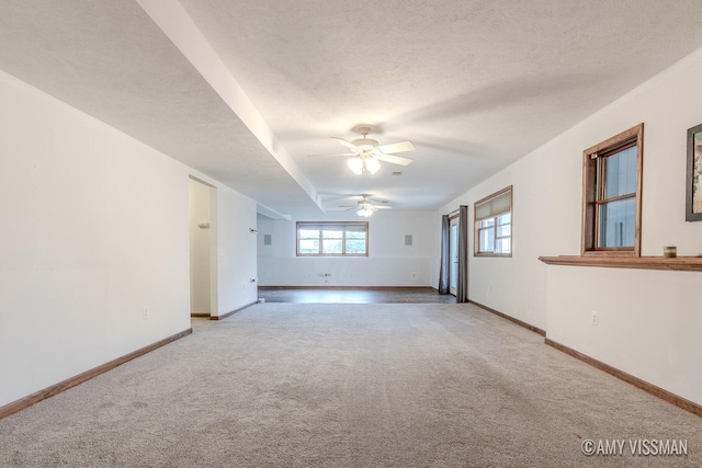 carpeted empty room featuring ceiling fan and a textured ceiling