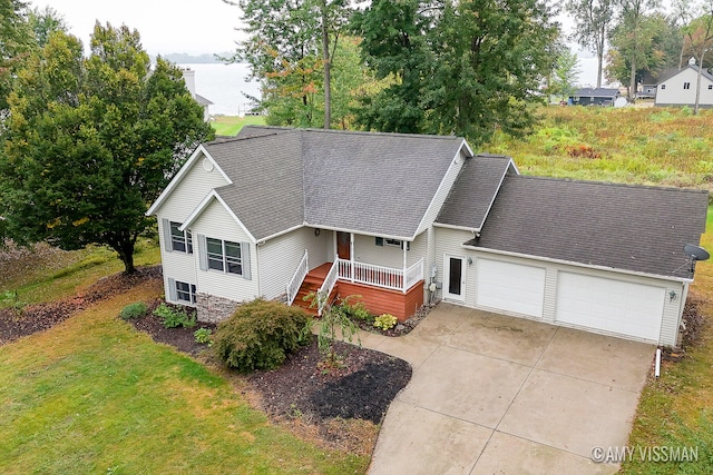 view of front of property with a garage, a front lawn, and a porch