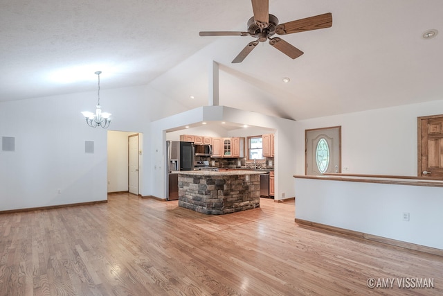 unfurnished living room featuring ceiling fan with notable chandelier, lofted ceiling, sink, and light hardwood / wood-style flooring