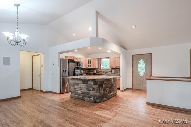 kitchen with appliances with stainless steel finishes, a chandelier, light hardwood / wood-style floors, and a center island