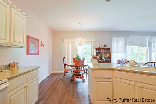 kitchen with an inviting chandelier, a healthy amount of sunlight, dark hardwood / wood-style floors, and pendant lighting