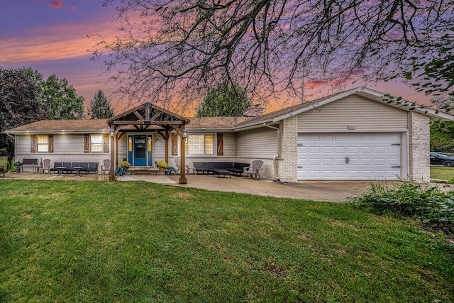 view of front facade with a lawn, an outdoor living space, and a garage