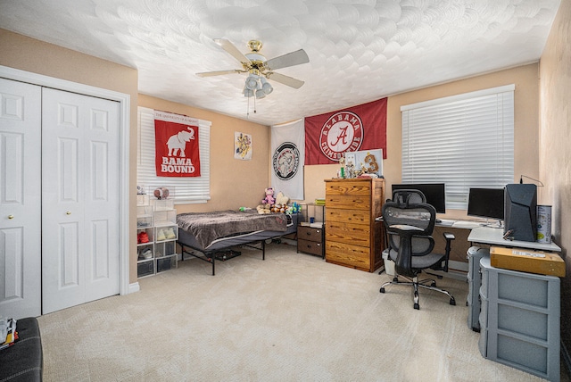 home office with ceiling fan, a textured ceiling, and carpet