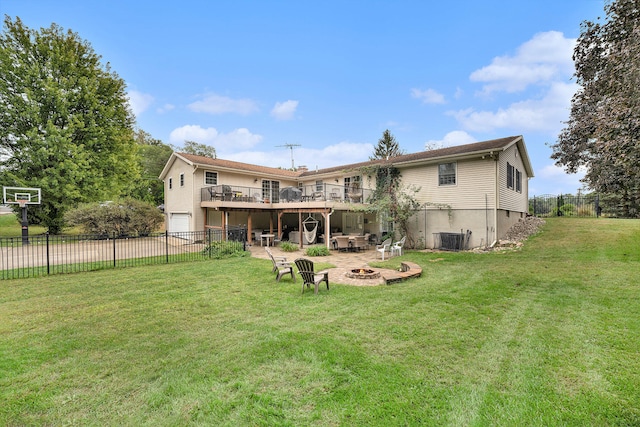 rear view of property featuring a lawn, a deck, and a fire pit