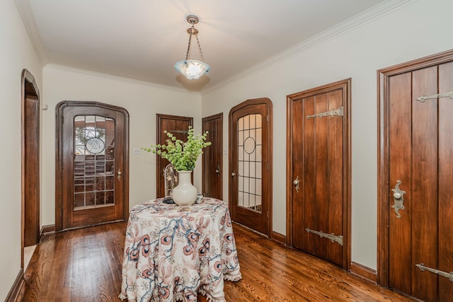 foyer with ornamental molding and dark hardwood / wood-style flooring