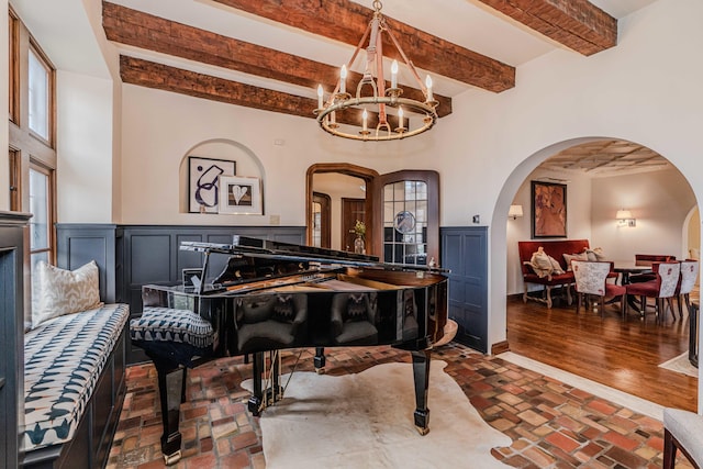 misc room with wood-type flooring, beam ceiling, and a chandelier