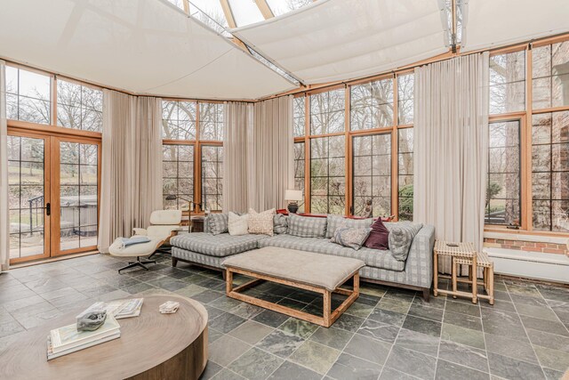 sunroom / solarium featuring french doors, a skylight, and a healthy amount of sunlight