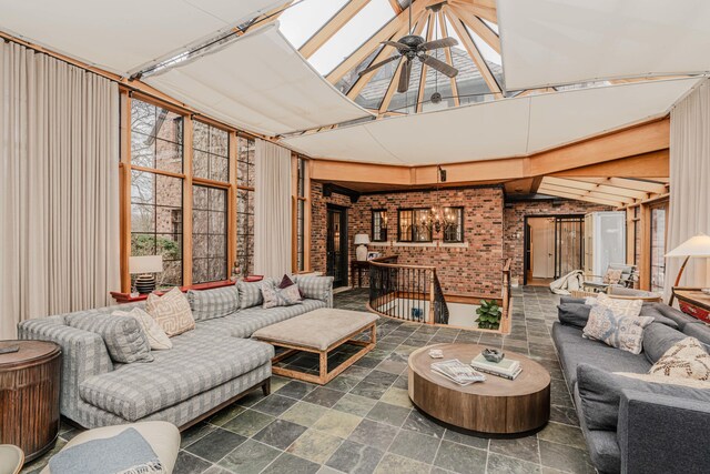 interior space featuring ceiling fan and vaulted ceiling with skylight