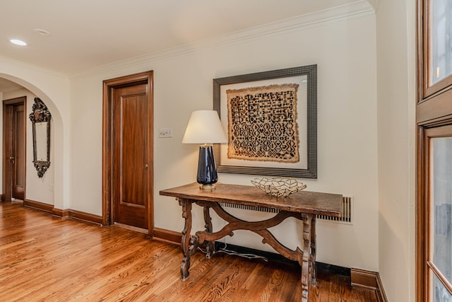 hallway with wood-type flooring and ornamental molding