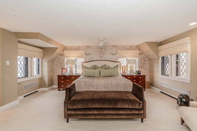 bedroom featuring radiator, multiple windows, light colored carpet, and ceiling fan