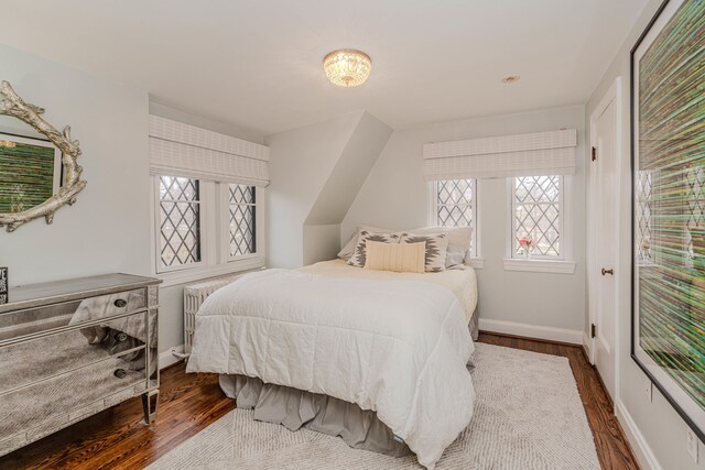 bedroom featuring radiator heating unit and dark wood-type flooring