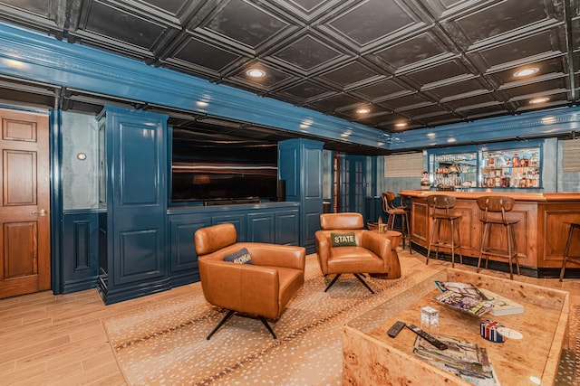 cinema with ornamental molding, indoor bar, wood-type flooring, and coffered ceiling