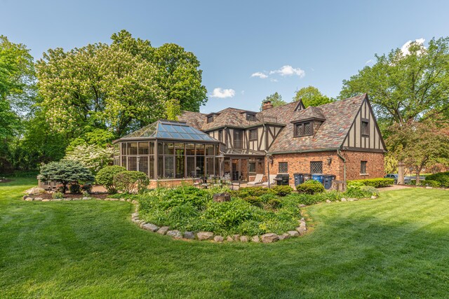 back of house featuring a sunroom, a yard, and a patio