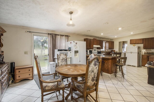 dining area featuring a textured ceiling and light tile patterned flooring