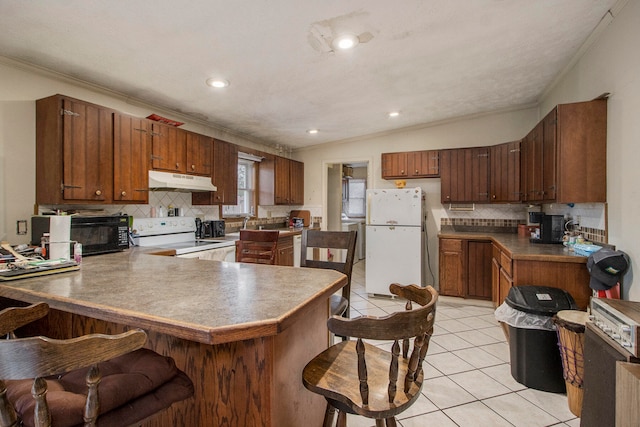 kitchen with white appliances, ornamental molding, and kitchen peninsula