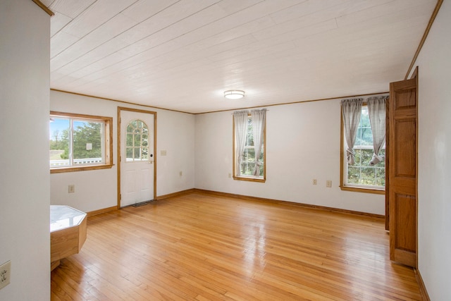 spare room featuring crown molding and light hardwood / wood-style floors