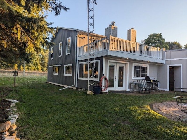 back of house featuring a lawn, a balcony, and a patio area