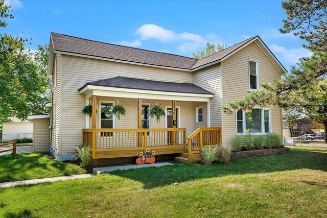 rear view of property with a porch and a yard