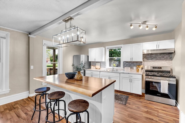 kitchen featuring appliances with stainless steel finishes, a healthy amount of sunlight, and white cabinetry