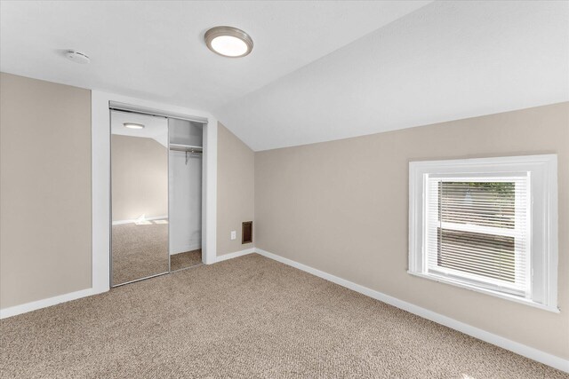 bonus room with lofted ceiling and carpet flooring