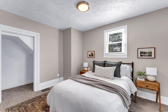 bedroom featuring carpet and a textured ceiling