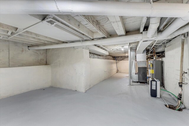 basement featuring water heater and heating unit